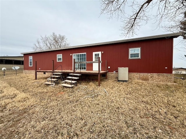 rear view of property featuring crawl space and cooling unit