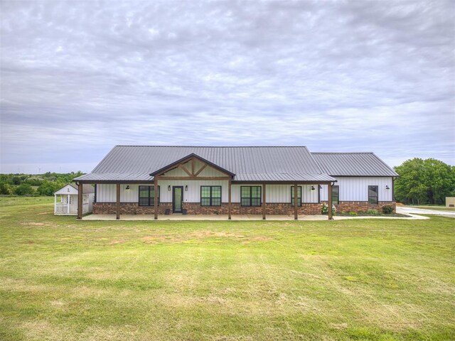 1632 County Road 1250, Tuttle, OK 73089 - view of front of house featuring a front yard, metal roof, a porch, and board and batten siding