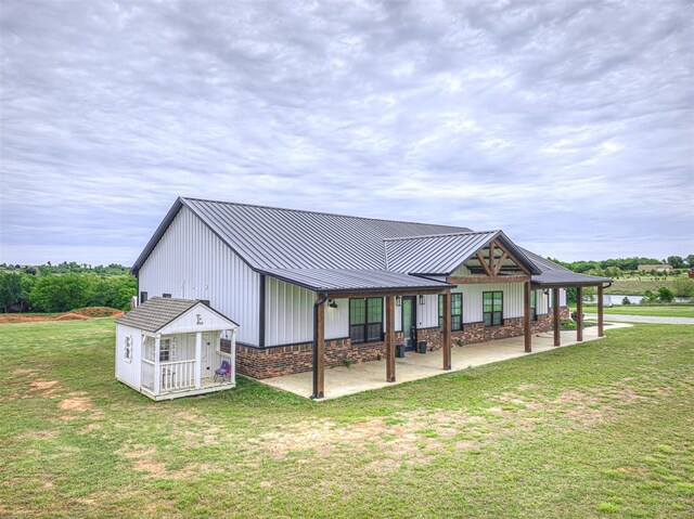 1632 County Road 1250, Tuttle, OK 73089 - back of house with a lawn, metal roof, a patio area, a standing seam roof, and board and batten siding