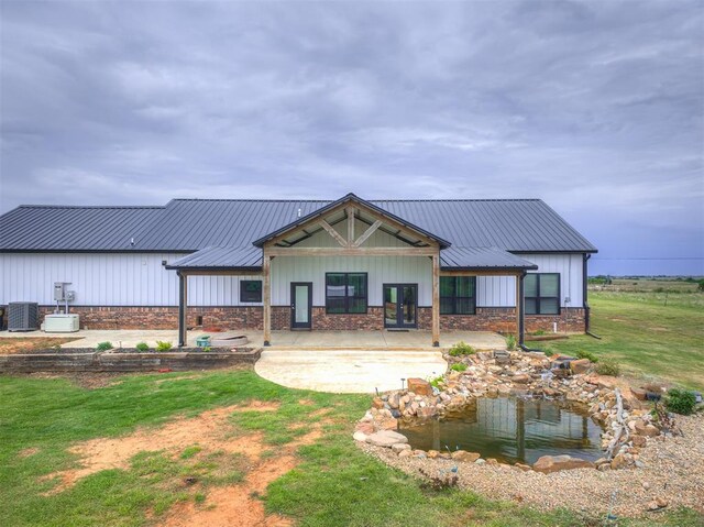 1632 County Road 1250, Tuttle, OK 73089 - rear view of property with central AC, board and batten siding, french doors, and metal roof