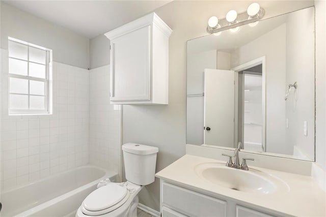 full bathroom featuring vanity, tiled shower / bath combo, and toilet