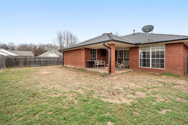 rear view of property with a yard and a patio