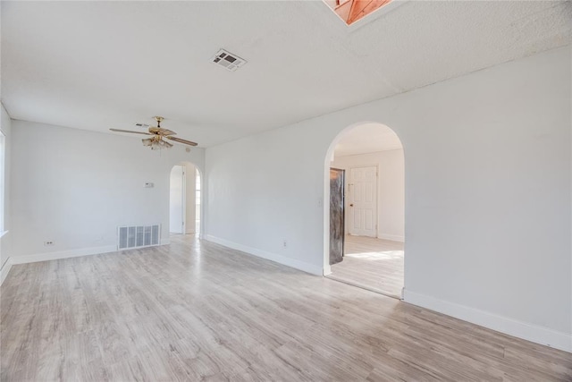 empty room with ceiling fan and light hardwood / wood-style flooring