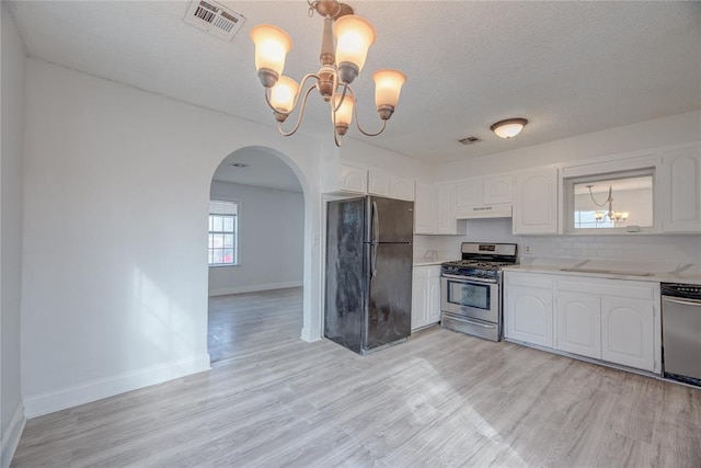 kitchen featuring light hardwood / wood-style flooring, stainless steel appliances, a notable chandelier, a textured ceiling, and white cabinets