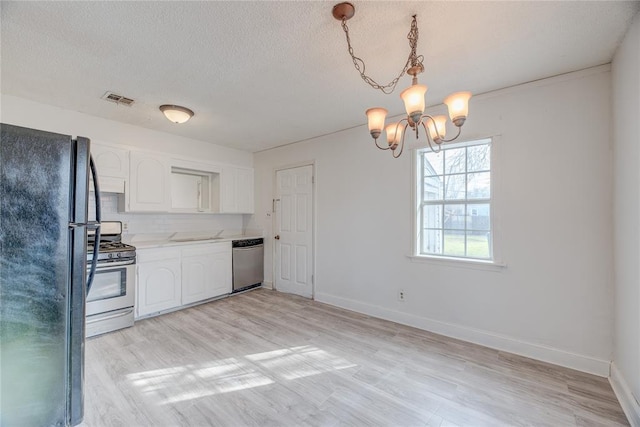 kitchen featuring white cabinetry, stainless steel appliances, a textured ceiling, a chandelier, and light wood-type flooring