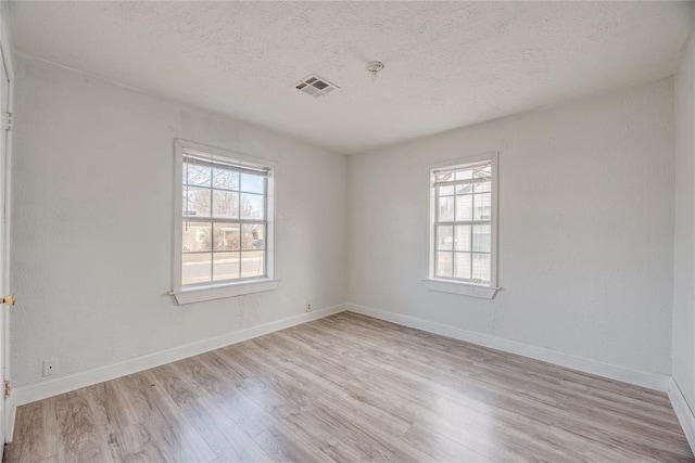 unfurnished room featuring a textured ceiling and light wood-type flooring