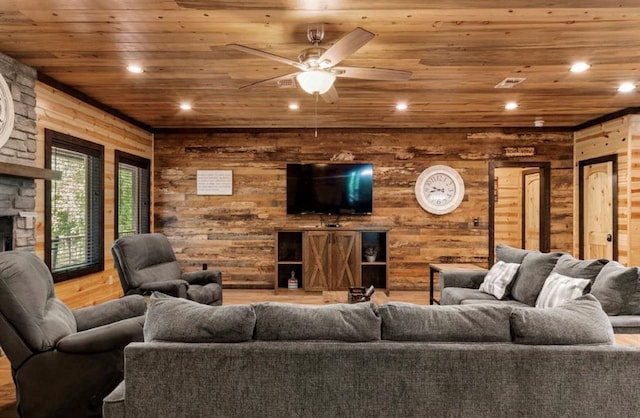 living room featuring wood ceiling, ceiling fan, a fireplace, and wooden walls