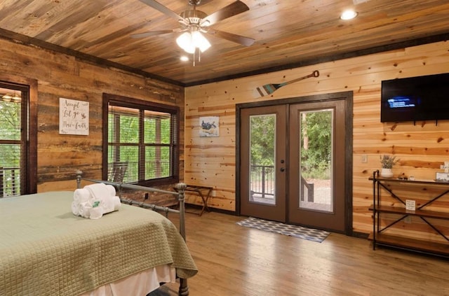 bedroom featuring hardwood / wood-style flooring, access to exterior, wooden ceiling, french doors, and wood walls