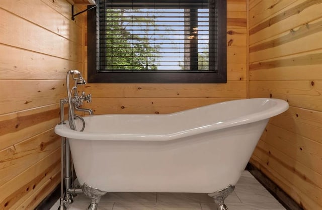 bathroom with a bath, tile patterned floors, and wood walls