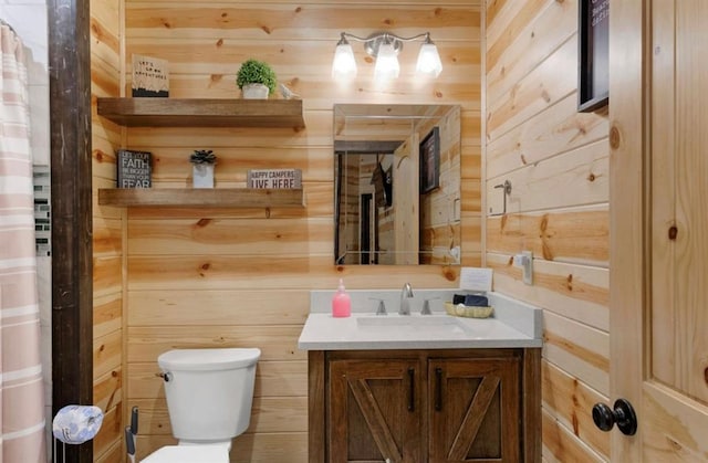 bathroom with vanity, toilet, and wood walls