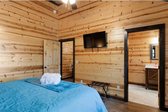 bedroom with wood-type flooring and wood walls