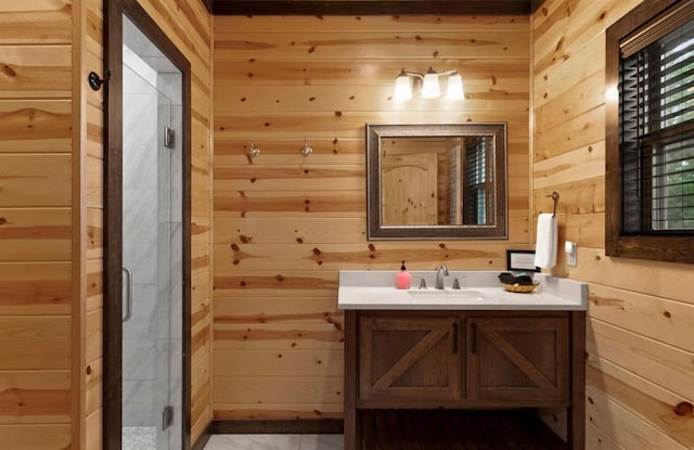 bathroom with vanity, wooden walls, and a shower with shower door