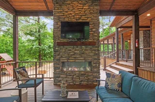 exterior space featuring plenty of natural light, wooden ceiling, and an outdoor stone fireplace