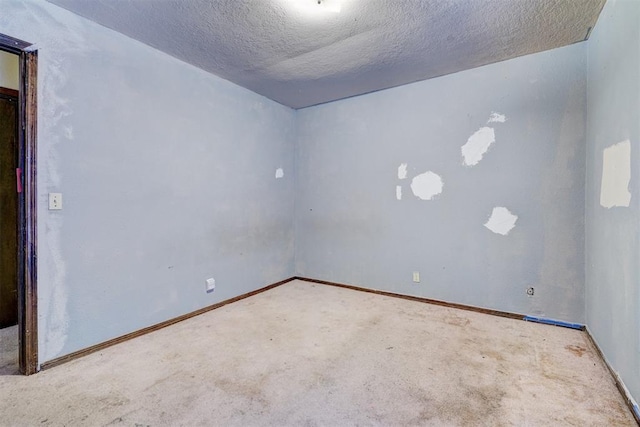 carpeted empty room featuring a textured ceiling