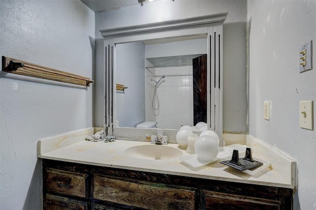 bathroom featuring vanity and tiled shower