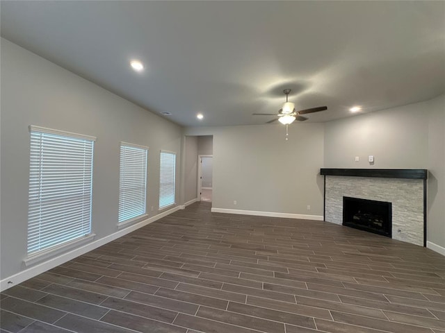 unfurnished living room featuring ceiling fan and a fireplace