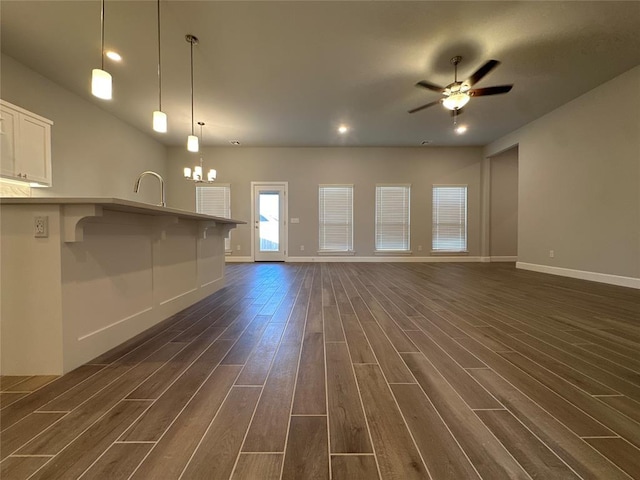 unfurnished living room featuring dark hardwood / wood-style floors and ceiling fan