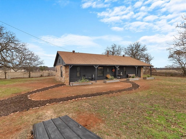 back of house featuring covered porch and a lawn