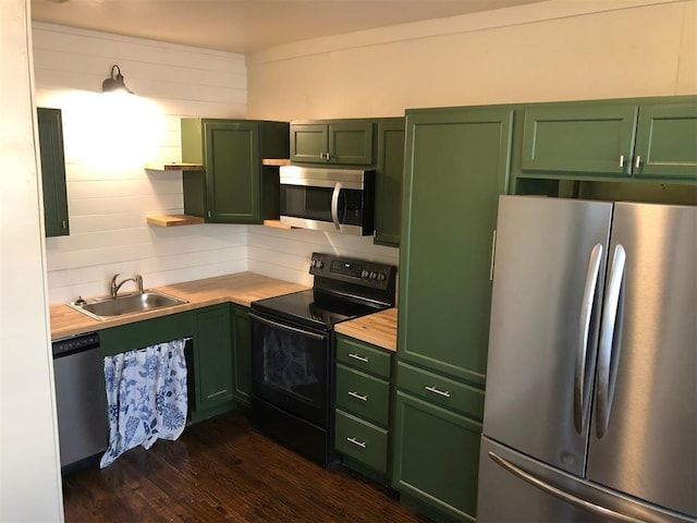 kitchen with dark hardwood / wood-style flooring, sink, stainless steel appliances, and green cabinetry