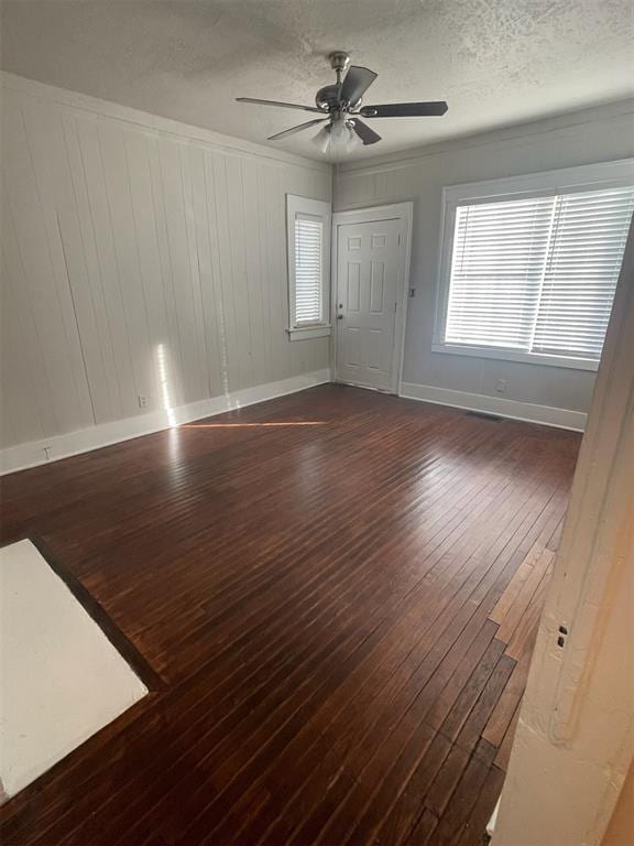 spare room with ceiling fan, ornamental molding, dark hardwood / wood-style flooring, and a textured ceiling