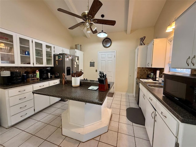 kitchen featuring appliances with stainless steel finishes, backsplash, white cabinets, a kitchen island, and light tile patterned flooring