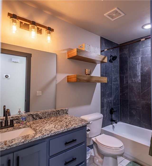 full bathroom featuring vanity, tile patterned flooring, tiled shower / bath combo, and toilet