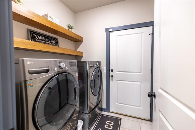 laundry room featuring washer and dryer and light tile patterned flooring