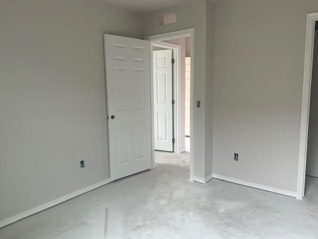 unfurnished bedroom featuring concrete floors and baseboards