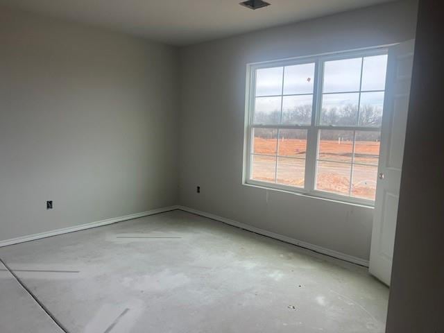 unfurnished room featuring baseboards and concrete floors