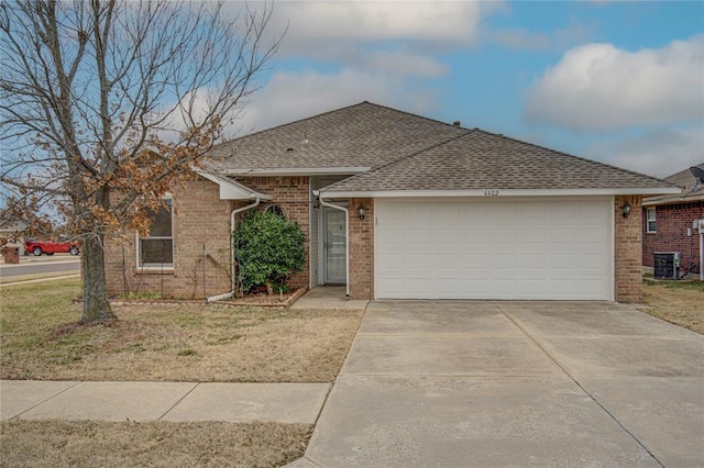 ranch-style home with a garage and central AC unit