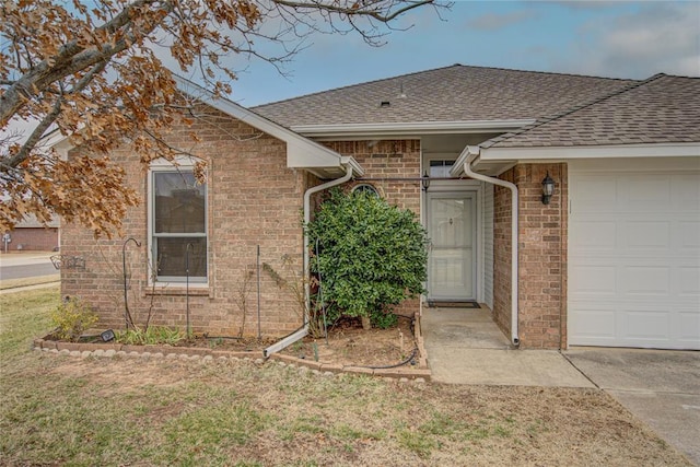 property entrance with a garage and a lawn