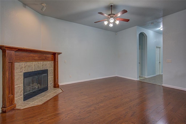 unfurnished living room featuring hardwood / wood-style flooring, a tile fireplace, and ceiling fan