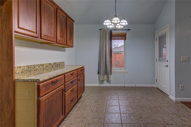 kitchen with lofted ceiling, a notable chandelier, and pendant lighting