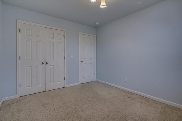 unfurnished bedroom featuring light colored carpet and a closet