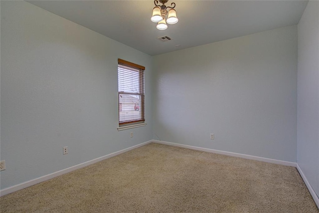 spare room with an inviting chandelier and carpet floors