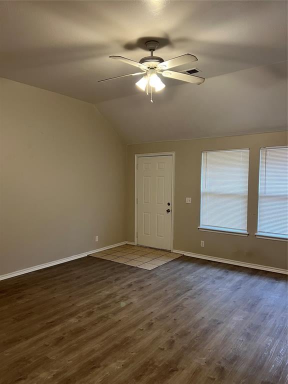 interior space featuring dark wood-type flooring, vaulted ceiling, and ceiling fan