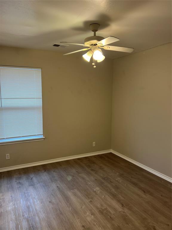 empty room with ceiling fan and dark hardwood / wood-style floors