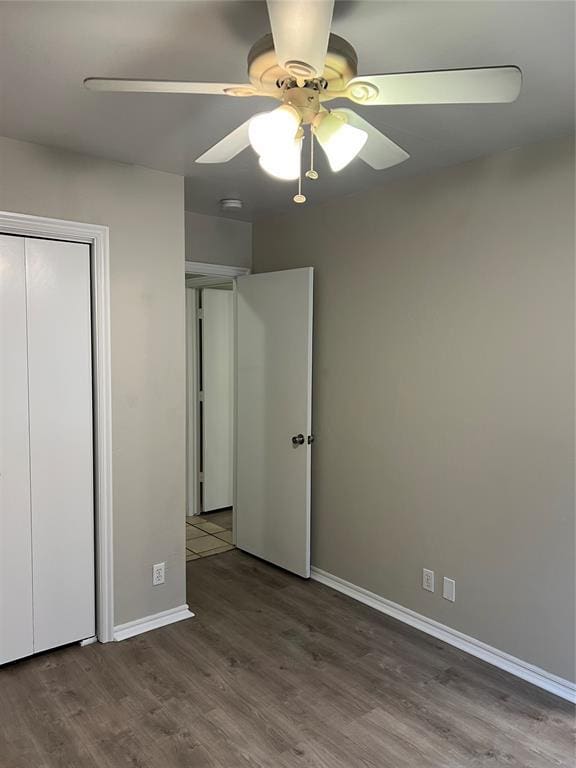 unfurnished bedroom featuring ceiling fan, wood-type flooring, and a closet