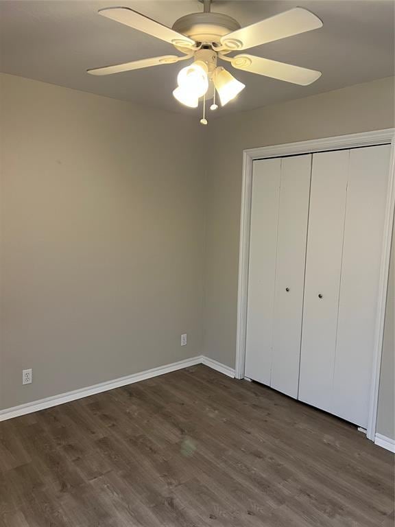 unfurnished bedroom featuring ceiling fan, dark hardwood / wood-style flooring, and a closet