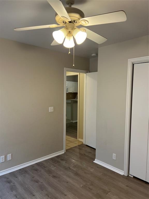 empty room with dark wood-type flooring and ceiling fan