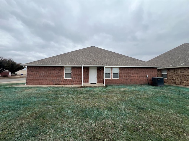 rear view of property featuring cooling unit and a yard