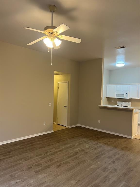 empty room with ceiling fan and dark hardwood / wood-style flooring