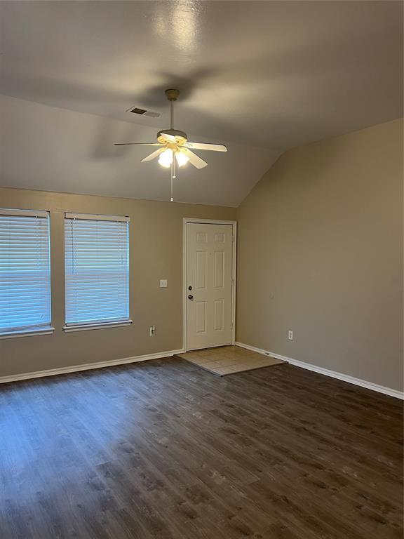 unfurnished room featuring ceiling fan, lofted ceiling, and dark hardwood / wood-style flooring