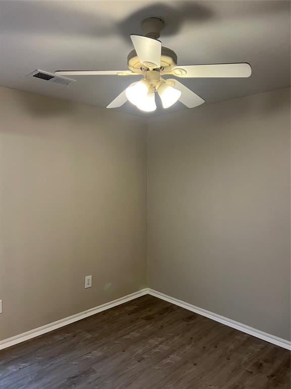 empty room with ceiling fan and dark hardwood / wood-style flooring