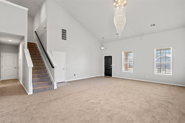 unfurnished living room with carpet flooring, a chandelier, and high vaulted ceiling