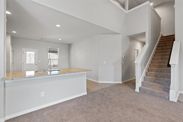 interior space featuring carpet floors, sink, and light stone counters