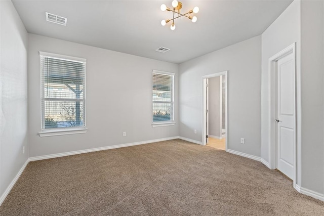 empty room featuring a notable chandelier and carpet flooring