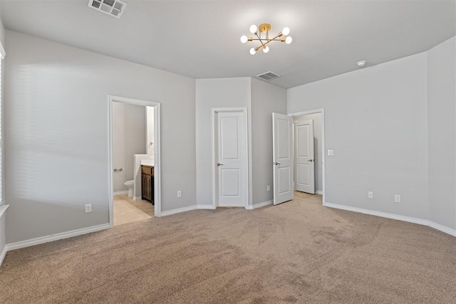 unfurnished bedroom featuring connected bathroom, light colored carpet, and an inviting chandelier