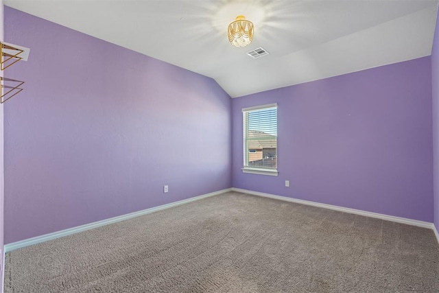 carpeted empty room with vaulted ceiling