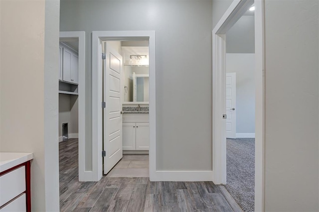 hall with sink and light hardwood / wood-style flooring